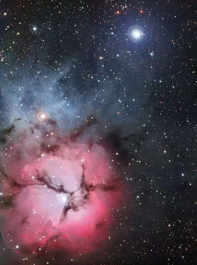 Der Trifidnebel Messier 20 (NGC 6514) im Sternbild Schütze, ein rosa leuchtender Emissionsnebel mit blauen Reflexionsbereichen, durchzogen von dunklen Staubbändern, aufgenommen mit dem MPG/ESO-2,2-Meter-Teleskop.