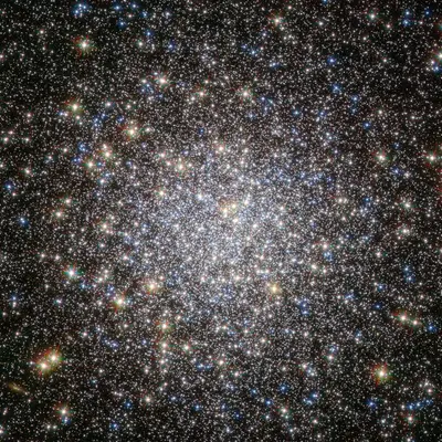 Der Kugelsternhaufen Messier 5 (NGC 5904) im Sternbild Schlange, einer der ältesten Kugelsternhaufen der Milchstraße, dicht gedrängte Sterne in Gelb, Blau und Rot, aufgenommen vom Hubble-Weltraumteleskop.