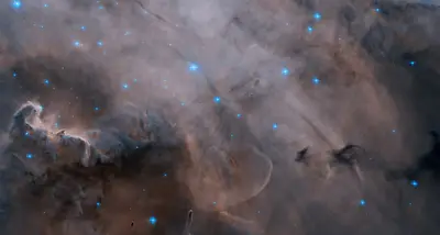 Wolken aus Gas und dunklem Staub im Lagunennebel, durchsetzt von hellen blauen Sternen