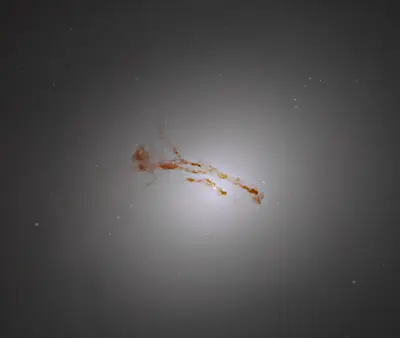 Hubble-Aufnahme des hellen Kerns der Galaxie M84 mit dunklen Staubbahnen, die quer durch das Zentrum verlaufen