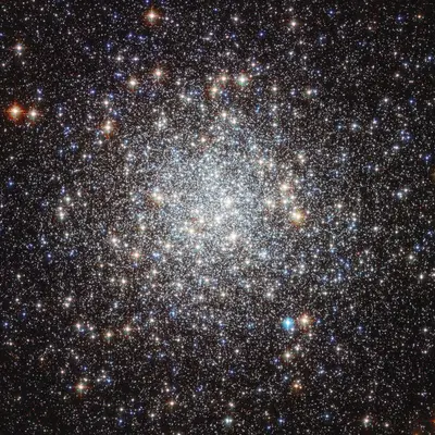 Der Kugelsternhaufen Messier 9 mit dicht gedrängten roten und blauen Sternen
